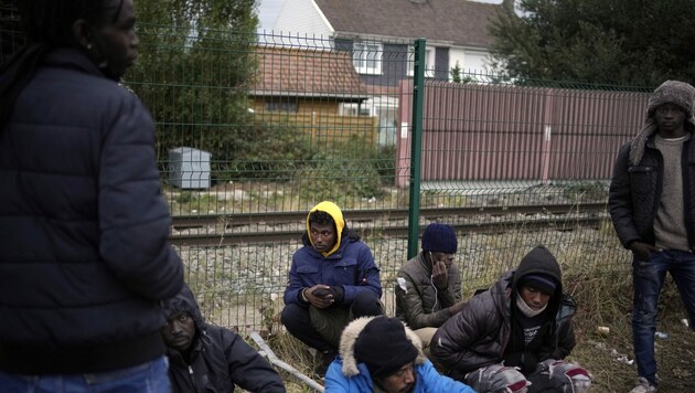 Migranten in der Nähe eines Flüchtlingscamps bei Calais (Bild: AP)