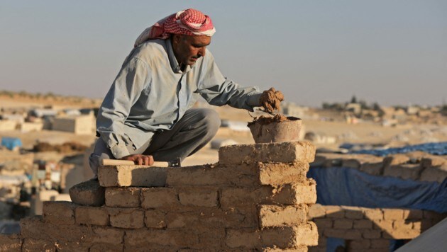 Ein Mann in al-Safira hilft dabei, ein zerstörtes Haus aufzubauen. (Bild: Bakr ALKASEM / AFP)