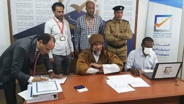 Saif al-Islam (sitzend in der Mitte) möchte zurück in die hohen Sphären der Macht in Libyen. (Bild: AP/Libyan High National Elections Commission)