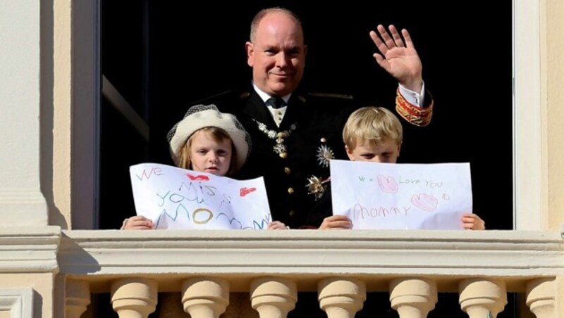 Fürst Albert II. mit den Zwillingen Gabriella und Jacques am Balkon des Palastes während der Feierlichkeiten zum Nationalfeiertag (Bild: APA/AFP/Valery HACHE)