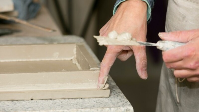 Wenn Michael alles mit den Fingern machen würde, hätte er am Abend wunde Hände, weil die feinen Körner wie Schleifpapier wirken. (Bild: Mathis Fotografie)