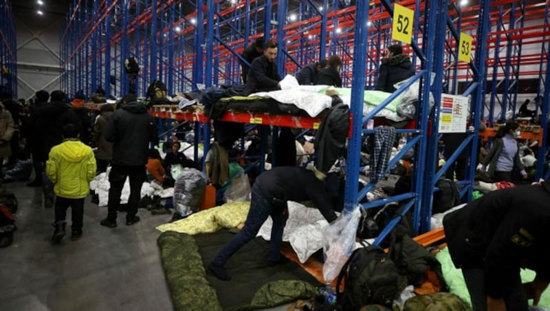 Das Zeltlager ist aufgelöst worden, nun sind Hunderte Migranten in dieser Lagerhalle in Grodno untergebracht. (Bild: APA/AFP/BELTA/Leonid SHCHEGLOV)