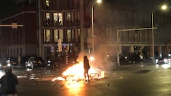 Ein Feuer auf der Straße in Den Haag während einer Demonstration. (Bild: APA/AFP/Danny KEMP)