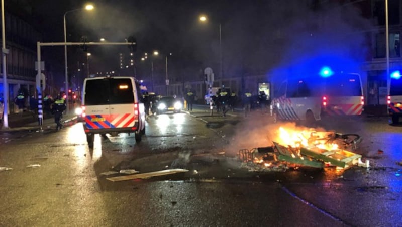 Randalierer bewarfen die Polizei mit Steinen und Feuerwerkskörpern, als die Proteste in den Niederlanden in der zweiten Nacht gewalttätig wurden. (Bild: APA/AFP/Danny KEMP)