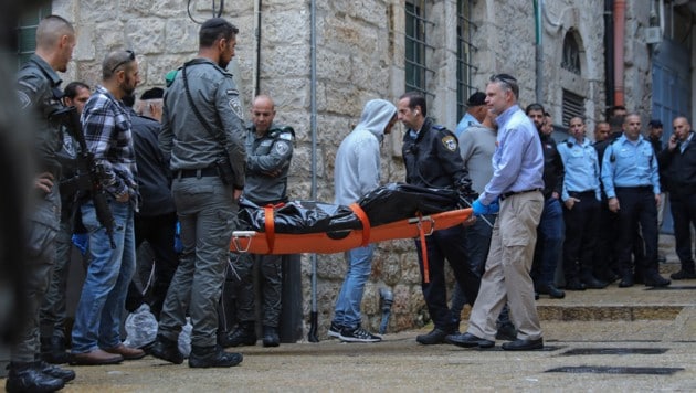 Israelische Sicherheits- und Rettungskräfte transportieren die Leiche des Attentäters ab. (Bild: ASSOCIATED PRESS)