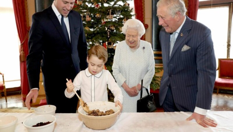 Prinz George rührt gemeinsam mit Prinz William, der Queen und Prinz Charles einen Christmaspudding an. (Bild: Chris Jackson / AP / picturedesk.com)