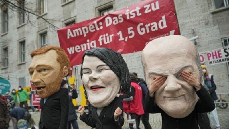 Aktivisten mit Masken von Christian Lindner, Annalena Baerbock und Olaf Scholz vor einem Treffen der Koalitionsverhandler (Bild: APA/dpa/Michael Kappeler)