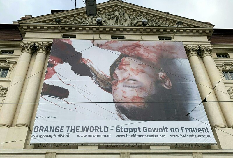 Eine blutverschmierte, offenbar ermordete Frau „ziert“ die Fassade der Grazer Oper. Künstler Gottfried Helnwein hat für die UN-Kampagne „Orange the World - 16 Tage gegen Gewalt an Frauen“ diese Fotokunst erschaffen. (Bild: APA/INGRID KORNBERGER)