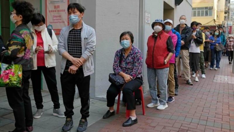 Lange Schlangen vor den Impfzentren im Hongkong (Bild: AP)