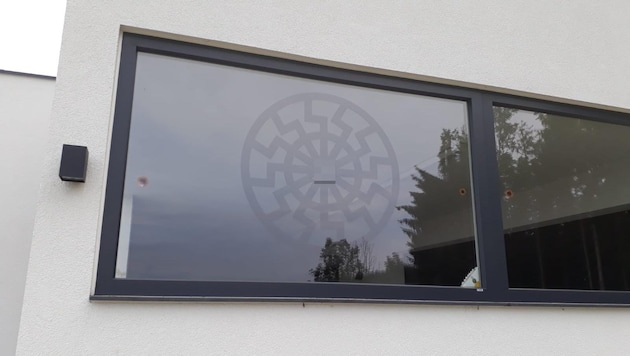 Am Fenster des Unternehmers in Wolfsegg/H. prangte öffentlich sichtbar eine große „Schwarze Sonne“, die unter Rechtsextremen auch als Erkennungszeichen verwendet wird. (Bild: zVg, Krone KREATIV)