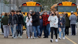 Eltern trösten vor der Schule ihre schockierten Kinder. (Bild: AP)