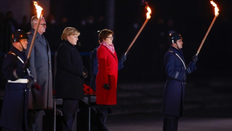 Bundeskanzlerin Angela Merkel (Mitte) verfolgt neben Verteidigungsministerin Annegret Kramp-Karrenbauer (r, beide CDU) und dem Generalinspekteur der Bundeswehr, General Eberhard Zorn, ihre Verabschiedung durch die Bundeswehr. (Bild: APA/AFP POOL/Odd Andersen)