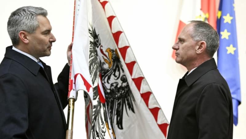 Karl Nehammer übergab seinem Nachfolger gemäß der Tradition die Fahne des Ressorts. (Bild: APA/HANS PUNZ)