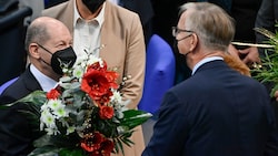 Nachdem Scholz zum neuen Bundeskanzler gewählt wurde, erhielt er Blumen vom Co-Fraktionsvorsitzenden und Spitzenkandidaten der Partei „Die Linke“, Dietmar Bartsch. (Bild: APA/AFP/John MACDOUGALL)