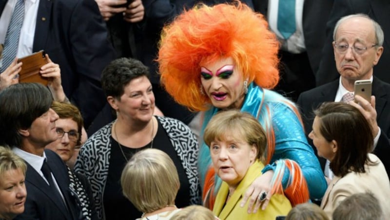 Bundeskanzlerin Angela Merkel (CDU, 2.v.r.), Dragqueen Olivia Jones (Mitte) und der Trainer der deutschen Fußball-Nationalmannschaft, Jogi Löw (li.) im Plenarsaal im Reichstagsgebäude vor der Wahl des Bundespräsidenten. (Bild: APA/dpa/Gregor Fischer)