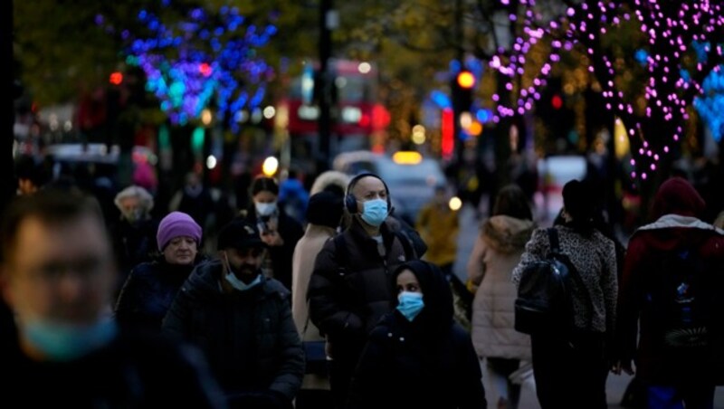 Auch im Freien tragen viele Briten Schutzmasken beim Shopping in der Oxford Street in London. (Bild: AP)