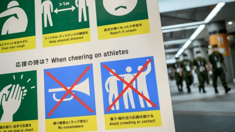 Ein Schild fasste zusammen, wie man sich angesichts der Corona-Lage bei den Olympischen Spielen in Tokio verhält. (Bild: AFP)