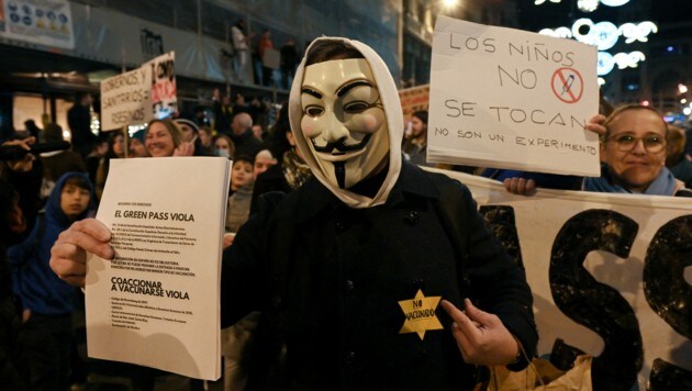Ein Demonstrant mit einer Anonymous-Maske nimmt an einer Demonstration gegen den Covid-19-Gesundheitspass in Barcelona teil. (Bild: APA/AFP/LLUIS GENE)