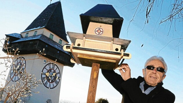 Erich Wack mit seiner Uhrturm-Miniatur, die Vögeln Futter bietet. (Bild: Christian Jauschowetz)