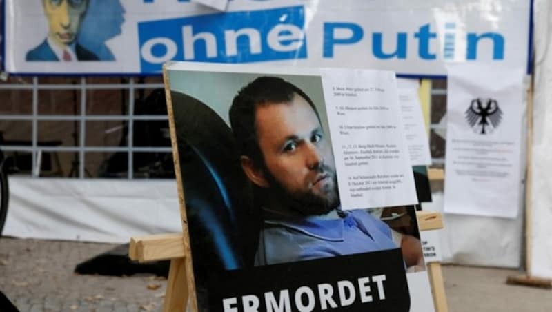 Bei einem Protest gegen den russischen Präsidenten wird das Opfer des Tiergarten-Mordes, Zelimkhan Khangoshvili, aud einem Poster gezeigt. (Bild: AFP )