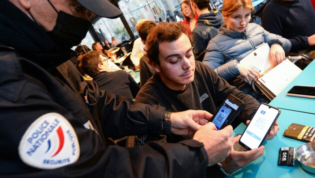 Ein Polizist kontrolliert den Gesundheitspass in einer Bar in Saint-Malo. (Bild: AFP)
