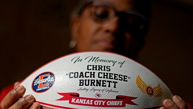 Carolyn Burnett hält den Football, der zu Ehren ihres an Covid-19 verstorbenen Sohnes angefertigt wurde. Chris Burnett war ungeimpft, er coachte die Mannschaft von Olathe East High School. (Bild: AP)