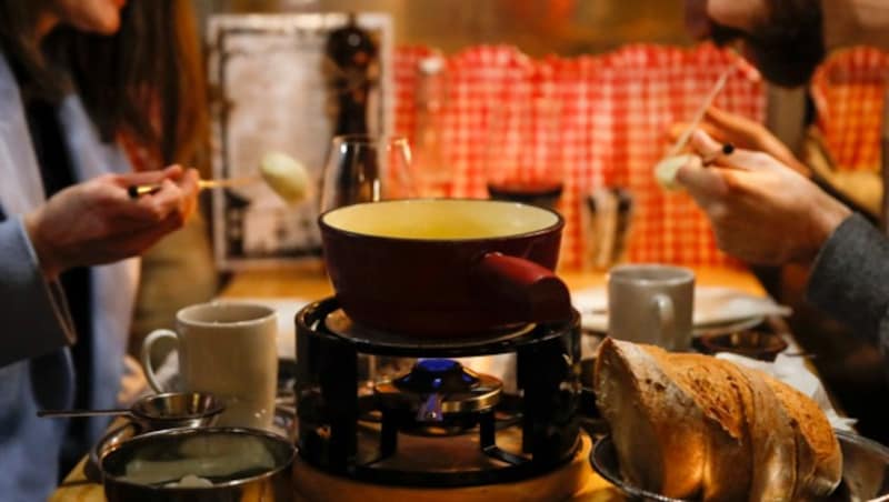 Traditionell wird das Fondue mit Käse und Brot gegessen, aber auch die Variante mit Fleisch oder Fisch in Öl oder Suppe ist beliebt. (Bild: AFP)