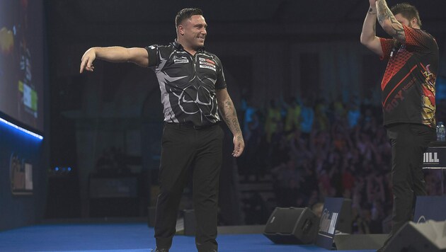 Gerwin Price (li.) bejubelt seinen Neun-Darter, selbst Konkurrent Michael Smith applaudiert. (Bild: Lawrence Lustig/PDC)