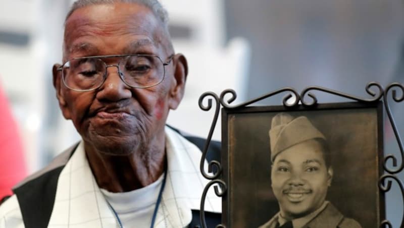 US-Veteran Lawrence Brooks mit 110 Jahren mit einem Foto von sich aus dem Jahr 1943. (Bild: APA/AP Photo/Gerald Herbert)