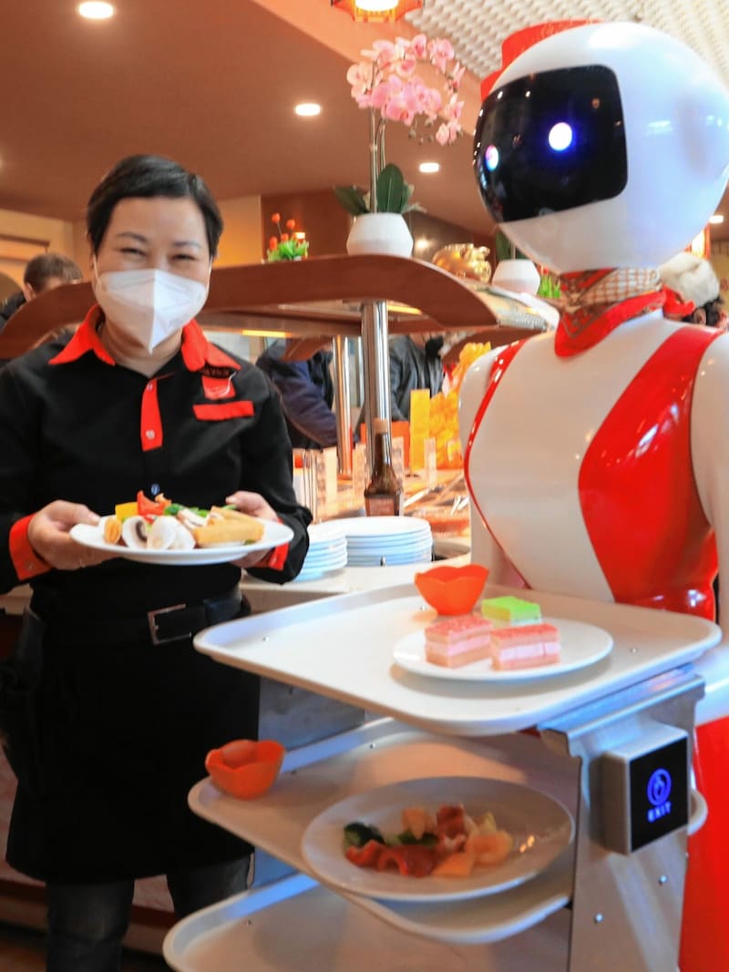 Chefin Vu Li mit dem Roboter, der im „Asia Wok“ am Klagenfurter Messegelände Speisen serviert. Gäste sind begeistert und lassen sich gern von der neuen Mitarbeiterin bedienen. (Bild: Rojsek-Wiedergut Uta)