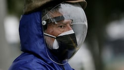 Dieser Herr nimmt es mit dem Infektionsschutz besonders ernst - gar so ausgefallen muss der Schutz vor Omikron aber nicht erfolgen. (Bild: AP/Dolores Ochoa)