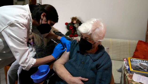 Booster-Impfung für eine Seniorin in Athen: Ältere Griechen werden nun zur Kasse gebeten, wenn sie nicht geimpft sind. (Bild: AP)