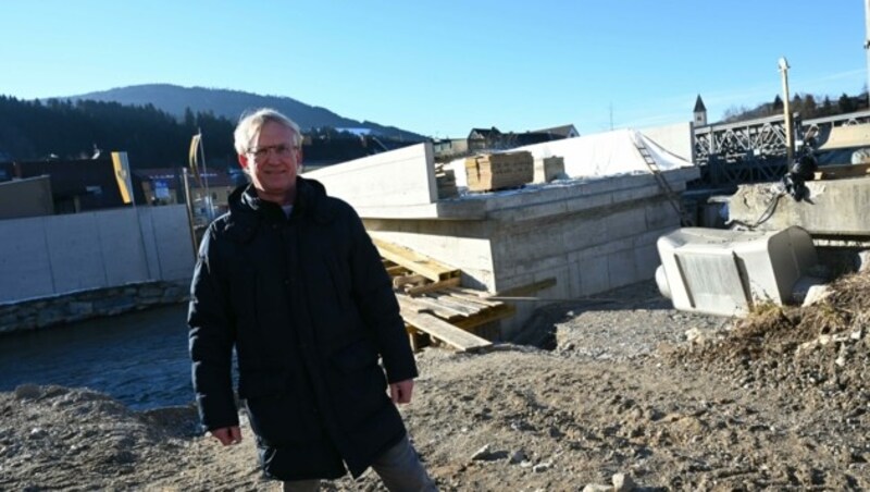 Lavamünds Bürgermeister Wolfgang Gallant vor der Baustelle der neuen Lavantbrücke, die wesentlich erhöht wird. Die meterhohen Schutzmauern stehen bereits. Es fehlt nur noch die Gestaltung und Begrünung. (Bild: Hronek Eveline)