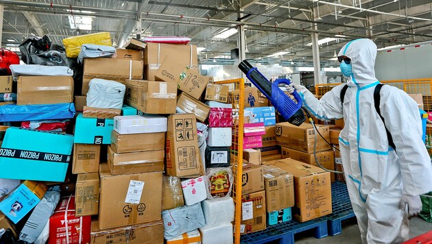 Pakete werden in diesem Logistikzentrum in Zhangye vor der weiteren Zustellung desinfiziert. (Bild: APA/AFP/STR)