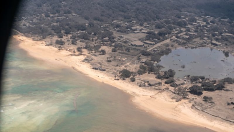 Ein von einem neuseeländischen Aufklärungsflugzeug geschossenes Foto zeigt von Asche bedeckte Häuser auf Tonga. (Bild: AP)