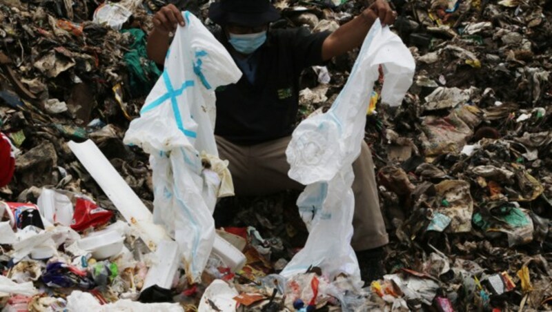Schutzanzüge liegen in Müllbergen. (Bild: AFP)
