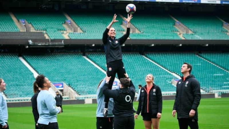 Geschafft! Die Spieler haben Herzogin Kate hoch, damit sie den Ball kriegt. (Bild: APA/Jeremy Selwyn/Pool Photo via AP)