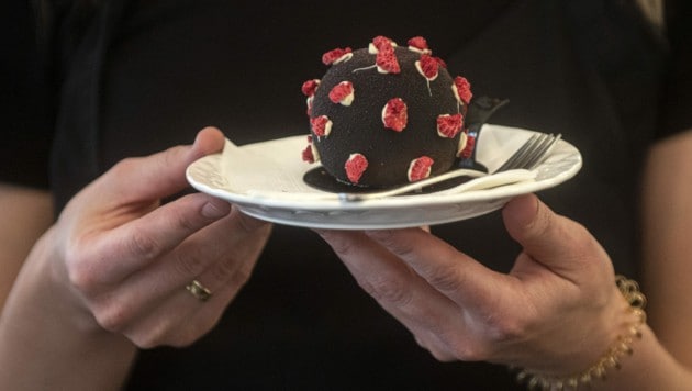 Eine Kellnerin serviert in einem Prager Café ein Dessert in Form eines Coronavirus. Die Zahl der Neuinfektionen ist aktuell auf einem Rekordhoch. (Bild: APA/AFP/Michal Cizek)