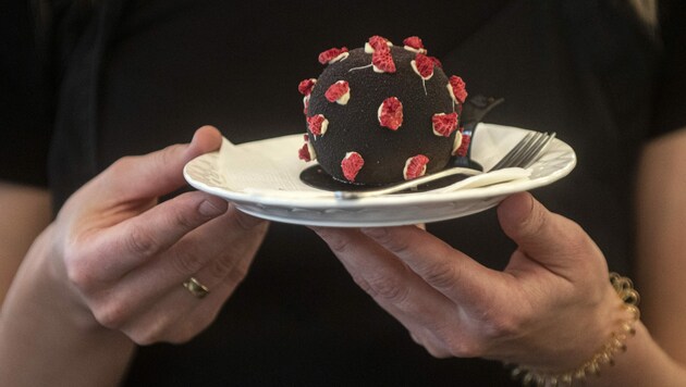 Eine Kellnerin serviert in einem Prager Café ein Dessert in Form eines Coronavirus. Die Zahl der Neuinfektionen ist aktuell auf einem Rekordhoch. (Bild: APA/AFP/Michal Cizek)