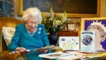 Queen Elizabeth liest sichtlich mit Vergnügen vor ihrem 70. Thronjubiläum noch einmal alte Glückwunschkarten und Andenken an zurückliegende Jubiläen. (Bild: APA/Steve Parsons/Pool via AP)