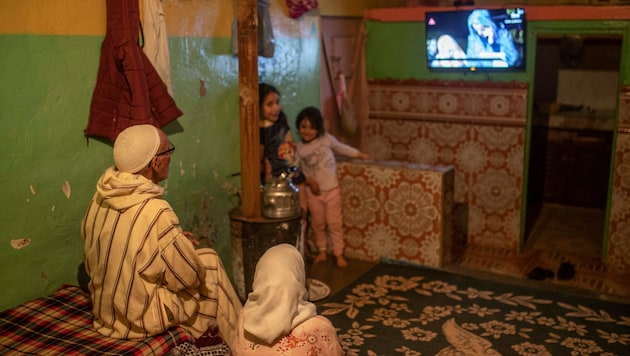 Eine Familie verfolgt eine im Fernsehen übertragene Erklärung, in der der Tod des 5-jährigen Rayan und ein Telefonat zwischen König Mohammed VI. und seinen Eltern angekündigt werden. (Bild: ASSOCIATED PRESS)
