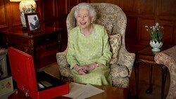 Queen Elizabeth sitzt lachend an ihrem Schreibtisch in Sandringham House in Norfolk. (Bild: APA/AFP PHOTO/BUCKINGHAM PALACE)