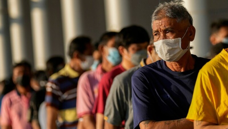 Wartende Menschen vor einem Impfzentrum in Bangkok (Bild: AP)