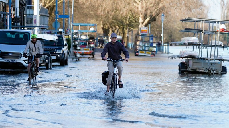 Ein Radfahrer fährt durch das Hochwasser an der Themse in Putney, London. (Bild: Associated Press)