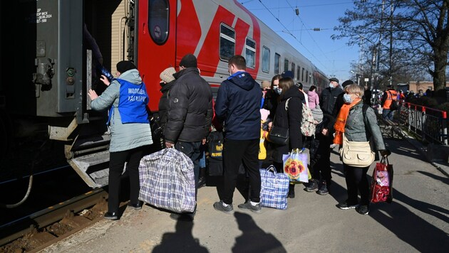 Menschen aus den Regionen Donezk und Luhansk, die von den pro-russischen Separatisten in der Ostukraine kontrolliert werden, steigen am russischen Bahnhof in Taganrog in einen Zug. Dieser soll sie zu vorübergehenden Unterkünften in anderen Regionen Russlands bringen. (Bild: The Associated Press)