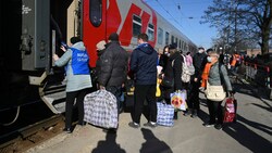 Menschen aus den Regionen Donezk und Luhansk, die von den pro-russischen Separatisten in der Ostukraine kontrolliert werden, steigen am russischen Bahnhof in Taganrog in einen Zug. Dieser soll sie zu vorübergehenden Unterkünften in anderen Regionen Russlands bringen. (Bild: The Associated Press)
