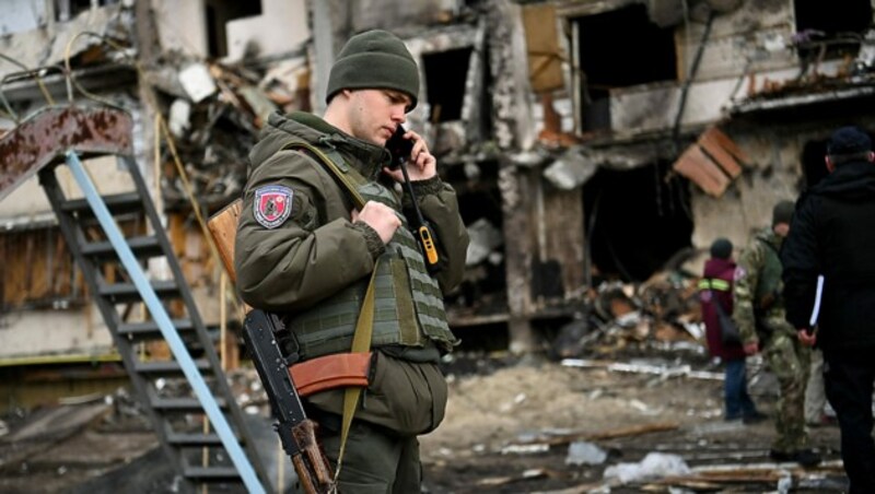 Ein ukrainischer Soldat vor einer Ruine in der ukrainischen Hauptstadt Kiew (Bild: APA/AFP/Daniel Leal)