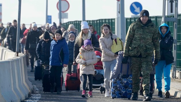 Ukrainische Familien mit Kindern überqueren in Krakovez die Grenze zu Polen. (Bild: AP)