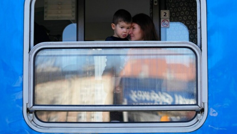 Eine Ukrainerin mit ihrem Sohn an Bord eines tschechischen Zuges, der noch einen Zwischenstopp in der polnischen Grenzstadt Przemysl gemacht hat (Bild: AP)