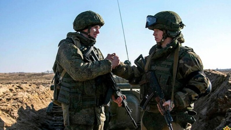 Handshake zwischen einem weißrussischen und einem russischen Soldaten während einer gemeinsamen Übung im Februar (Bild: APA/AFP/MINISTRY OF DEFENCE REPUBLIC OF BELARUS/Handout)